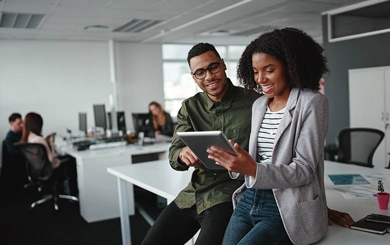 Successful african american business couple talking and using digital tablet